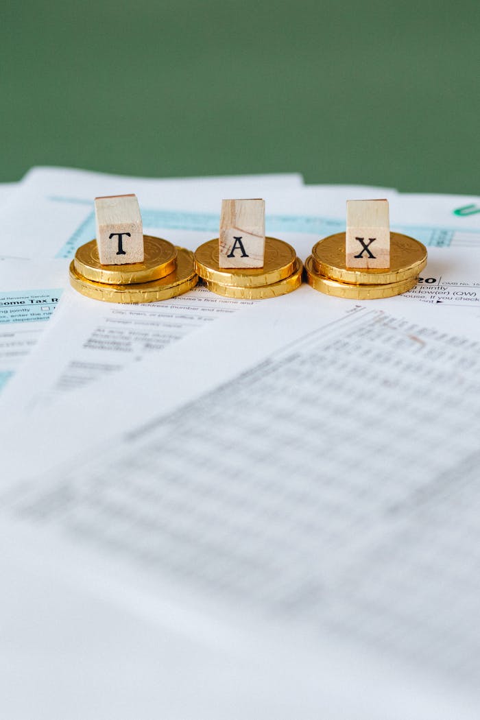 Crafting Captivating Headlines: Your awesome post title goes here Staged image of gold coins with tax letter tiles on documents.